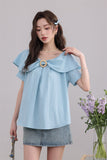 เสื้อเบลาส์สีฟ้ามีระบายและวงแหวนตกแต่ง